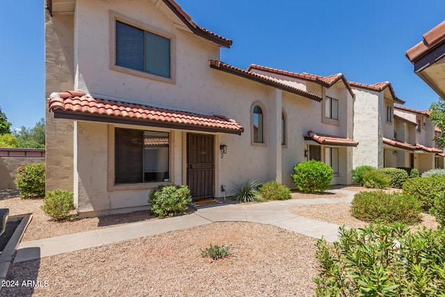 mediterranean / spanish-style house featuring a tiled roof and stucco siding