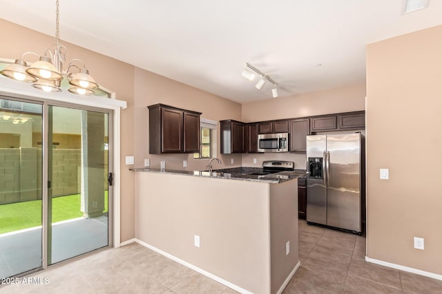 2725 E Mine Creek Rd Unit 1149, Phoenix, AZ 85024 - kitchen featuring appliances with stainless steel finishes, dark brown cabinets, light tile patterned floors, dark stone counters, and a chandelier