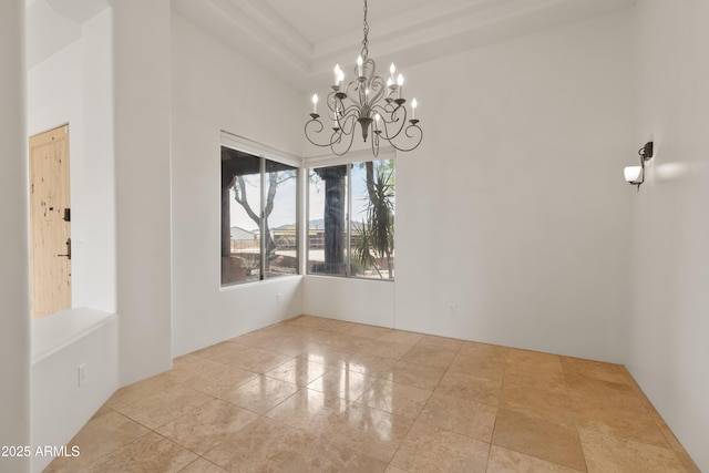 unfurnished room with a towering ceiling and a notable chandelier