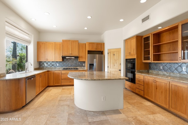 kitchen with light stone countertops, a sink, a center island, visible vents, and black appliances