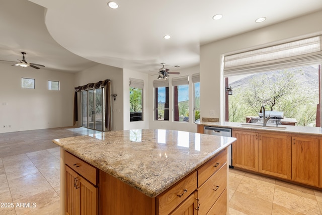kitchen with a sink, a center island, a ceiling fan, open floor plan, and stainless steel dishwasher