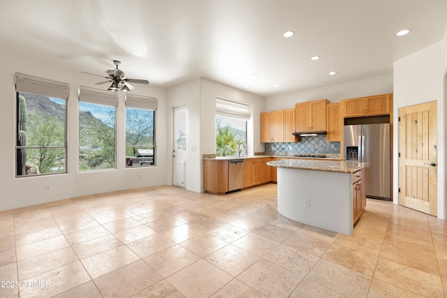 kitchen featuring ceiling fan, a center island, recessed lighting, backsplash, and stainless steel appliances