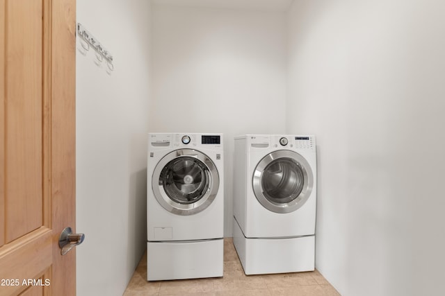 laundry room featuring light tile patterned floors, laundry area, and washer and dryer
