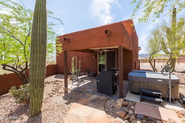 back of house featuring a hot tub, a patio, ceiling fan, and a fenced backyard