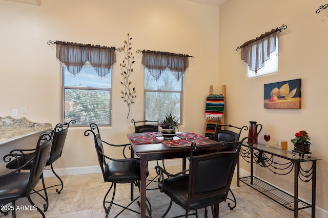 dining space featuring baseboards and light tile patterned flooring