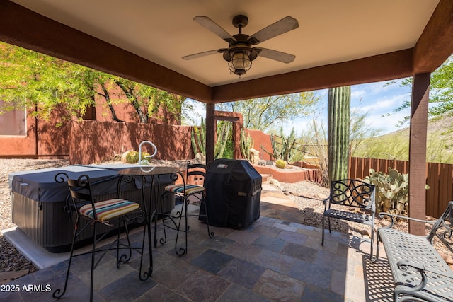 view of patio featuring ceiling fan, outdoor dining area, a hot tub, a fenced backyard, and a grill