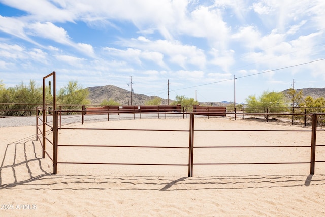 view of community with a rural view, fence, and a mountain view