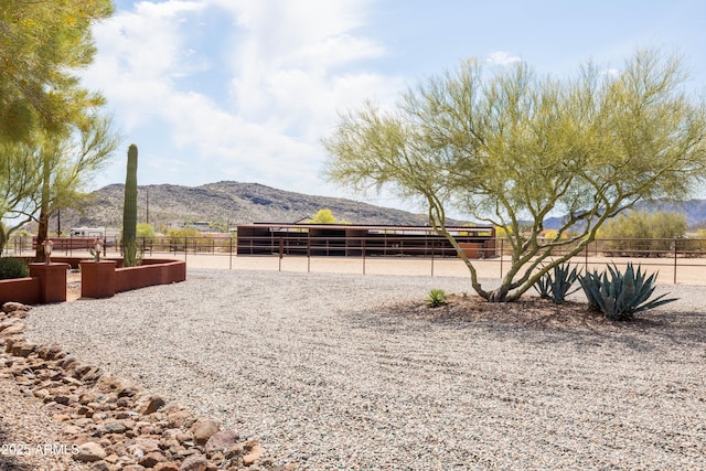 view of yard with an exterior structure, an outbuilding, a mountain view, and an enclosed area