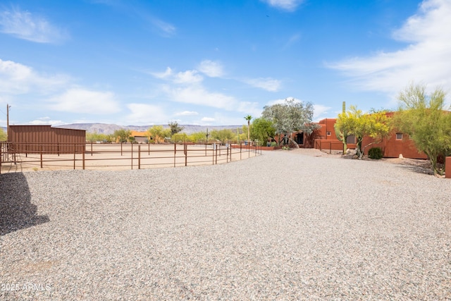 view of yard with an outdoor structure, a mountain view, and an enclosed area