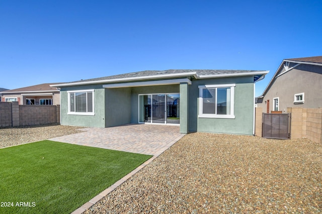 back of property featuring a patio and a lawn