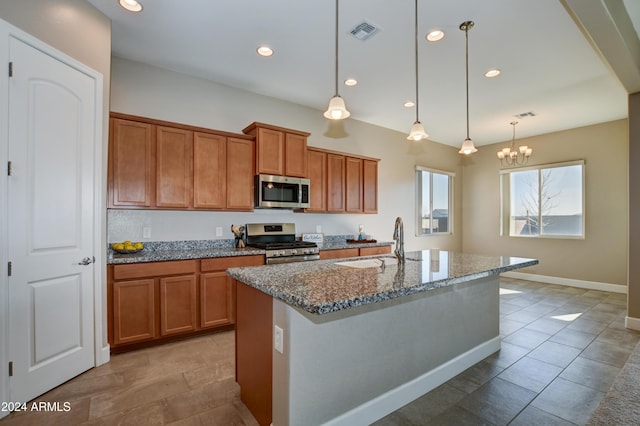 kitchen with pendant lighting, a kitchen island with sink, an inviting chandelier, sink, and appliances with stainless steel finishes