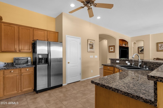 2069 E Winchester Way, Chandler, AZ 85286 - kitchen with stainless steel refrigerator with ice dispenser, arched walkways, a ceiling fan, brown cabinets, and light tile patterned flooring
