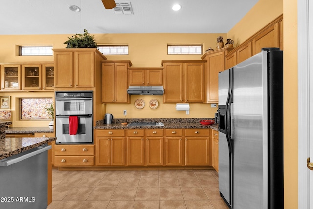 2069 E Winchester Way, Chandler, AZ 85286 - kitchen with stainless steel appliances, under cabinet range hood, dark stone counters, glass insert cabinets, and light tile patterned flooring
