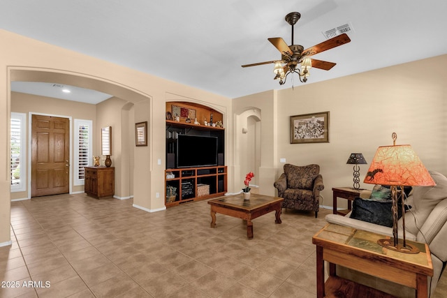 2069 E Winchester Way, Chandler, AZ 85286 - living area with arched walkways, ceiling fan, and light tile patterned flooring
