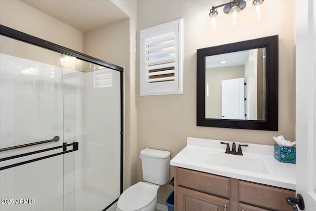 full bath featuring toilet, a shower stall, and vanity