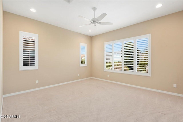 empty room featuring recessed lighting, light colored carpet, and baseboards