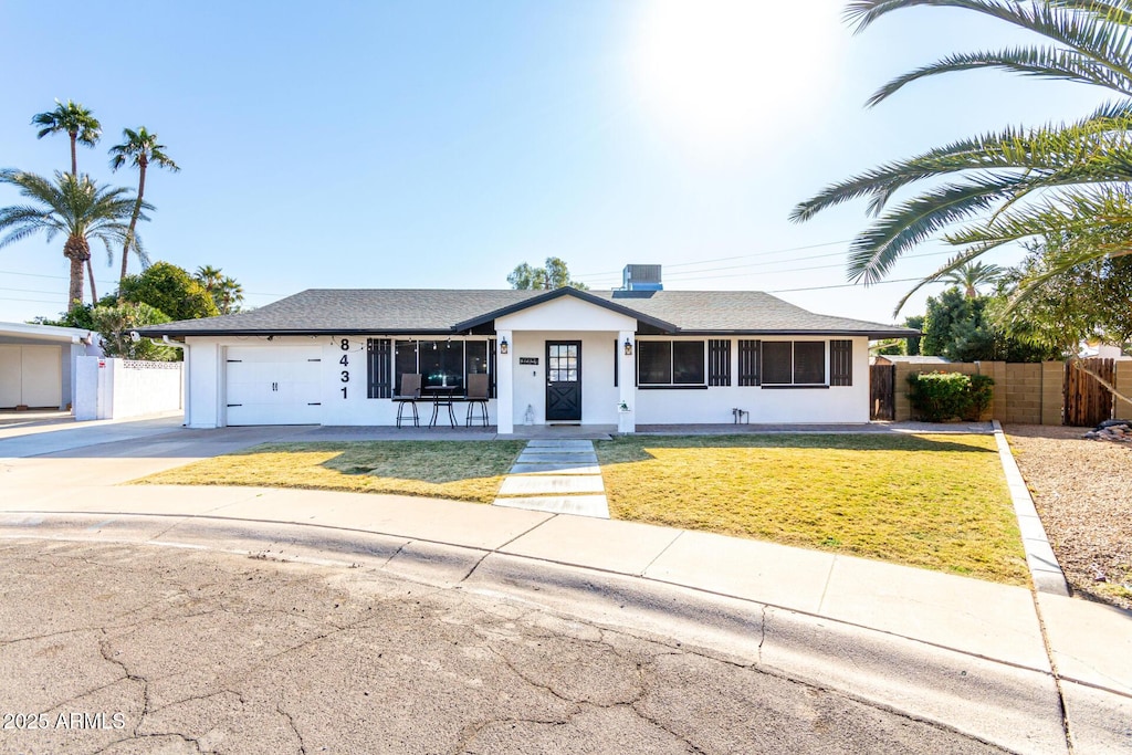 ranch-style house featuring a front lawn and a garage