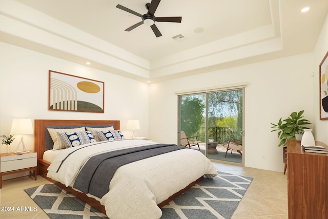 tiled bedroom with a raised ceiling, ceiling fan, and access to exterior