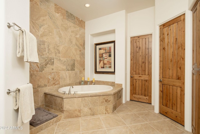 bathroom with tile patterned flooring and a relaxing tiled tub