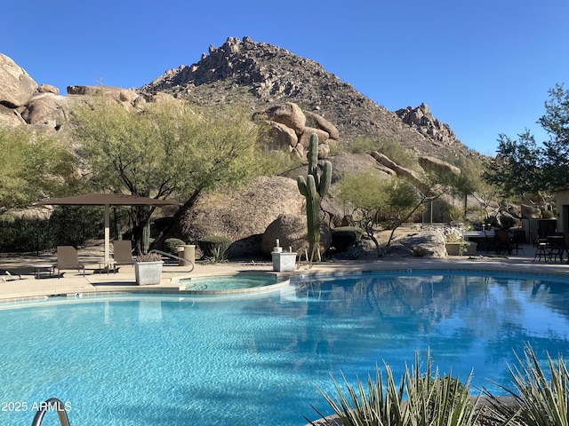 view of swimming pool featuring a mountain view, an in ground hot tub, and a patio