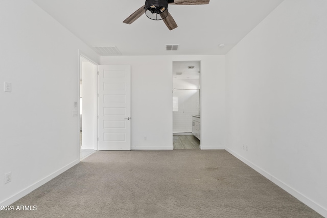 unfurnished bedroom featuring ceiling fan, light carpet, and connected bathroom