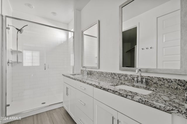 bathroom with wood-type flooring, vanity, and a shower with shower door