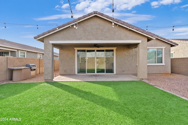 rear view of house featuring a patio, ceiling fan, and a lawn