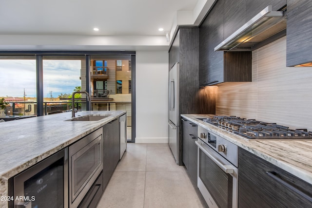 kitchen featuring light stone countertops, decorative backsplash, stainless steel appliances, and sink