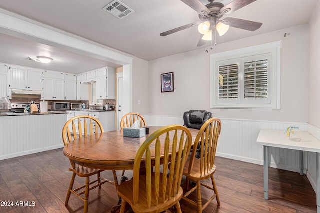 dining space with ceiling fan and dark wood-type flooring