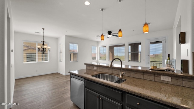 kitchen featuring dishwasher, hardwood / wood-style floors, an inviting chandelier, sink, and pendant lighting