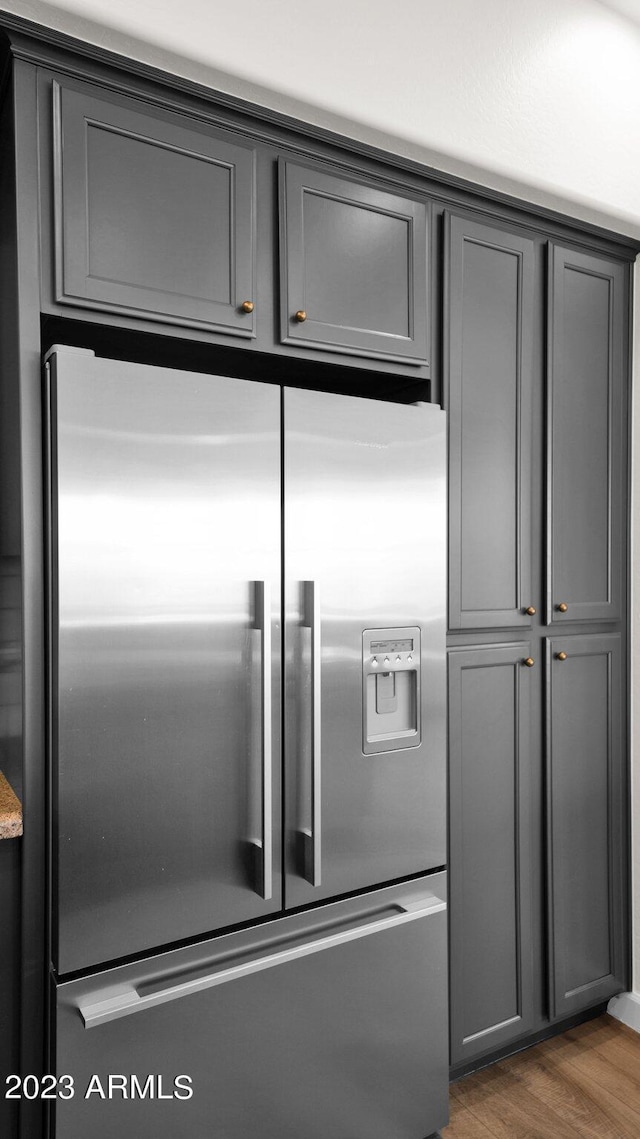 kitchen featuring high end fridge, wood finished floors, and gray cabinetry