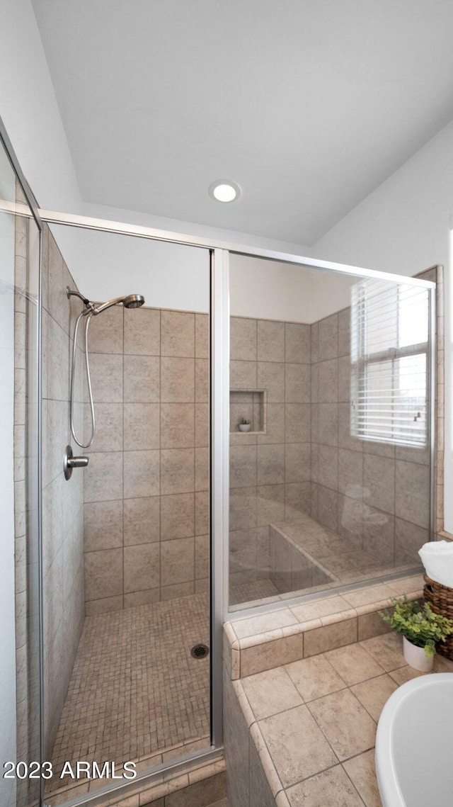 full bath featuring a tub and a shower stall