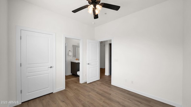 unfurnished bedroom featuring ceiling fan, wood-type flooring, and ensuite bath