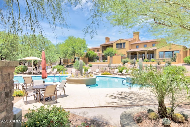 community pool with a patio and fence