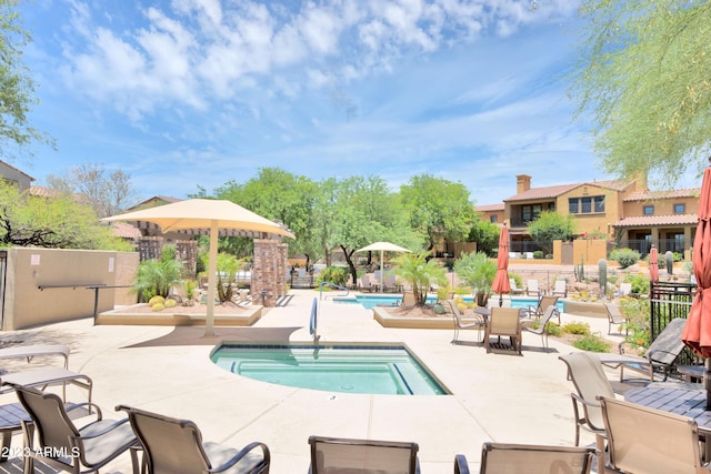 community pool with fence and a patio