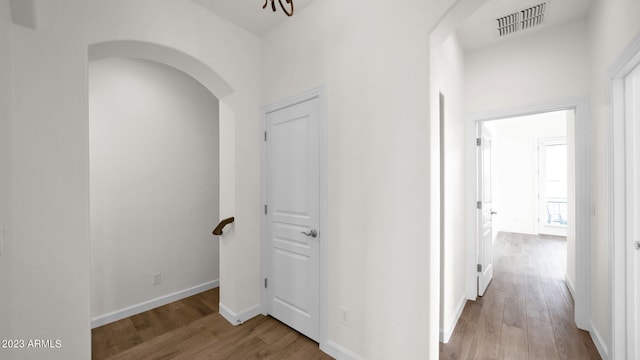 corridor with hardwood / wood-style flooring