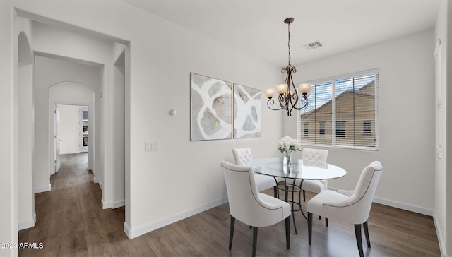 dining space featuring dark hardwood / wood-style floors and a chandelier