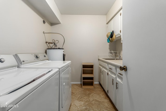 clothes washing area featuring washer and clothes dryer, cabinets, sink, and electric water heater