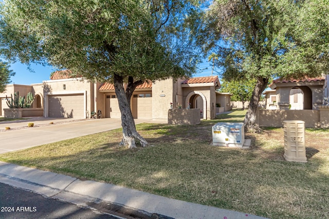 mediterranean / spanish-style home with a garage and a front yard