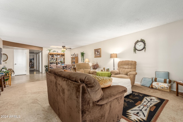 carpeted living room featuring a textured ceiling and ceiling fan