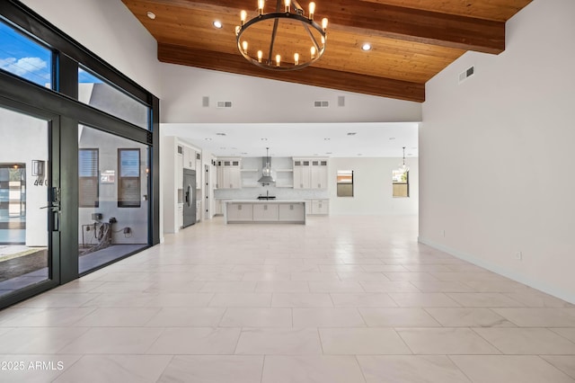 unfurnished living room featuring a notable chandelier, visible vents, wooden ceiling, and high vaulted ceiling