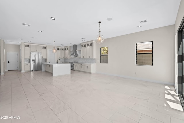 unfurnished living room with recessed lighting, visible vents, baseboards, and a sink