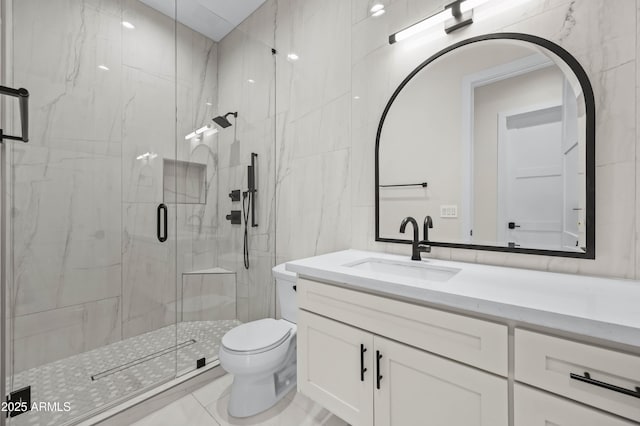 bathroom featuring vanity, tile walls, toilet, and a marble finish shower