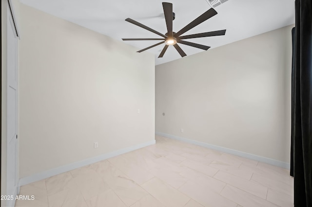 unfurnished room with a ceiling fan and baseboards