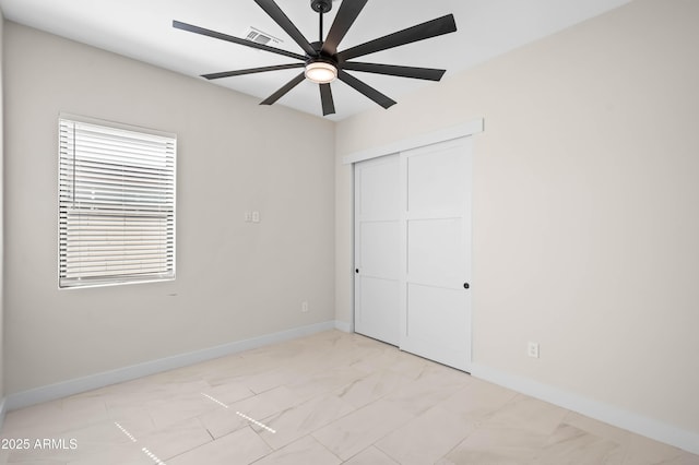 unfurnished bedroom with a closet, baseboards, visible vents, and a ceiling fan