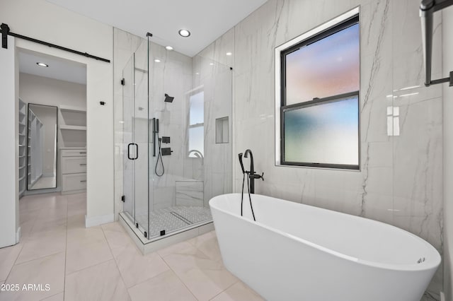 bathroom with a soaking tub, recessed lighting, a stall shower, tile walls, and marble finish floor