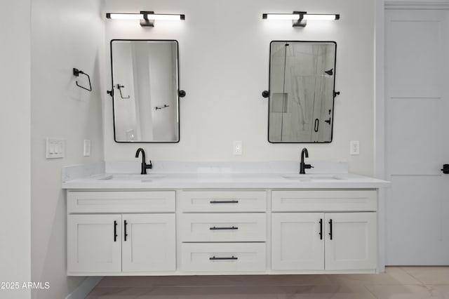 bathroom featuring a sink, double vanity, and a shower stall