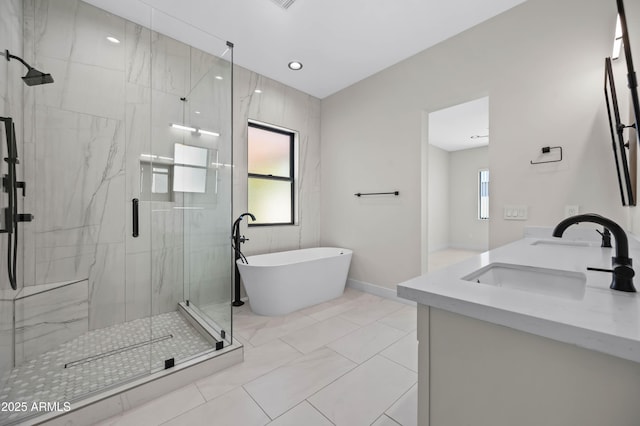 bathroom with a marble finish shower, a soaking tub, and a sink