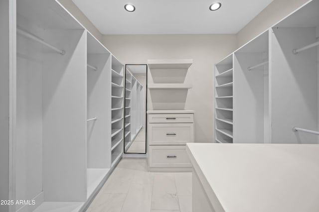 walk in closet with marble finish floor