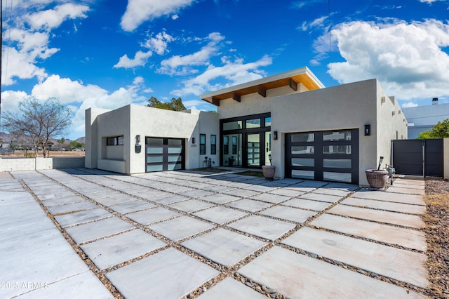 contemporary house featuring concrete driveway, an attached garage, and stucco siding